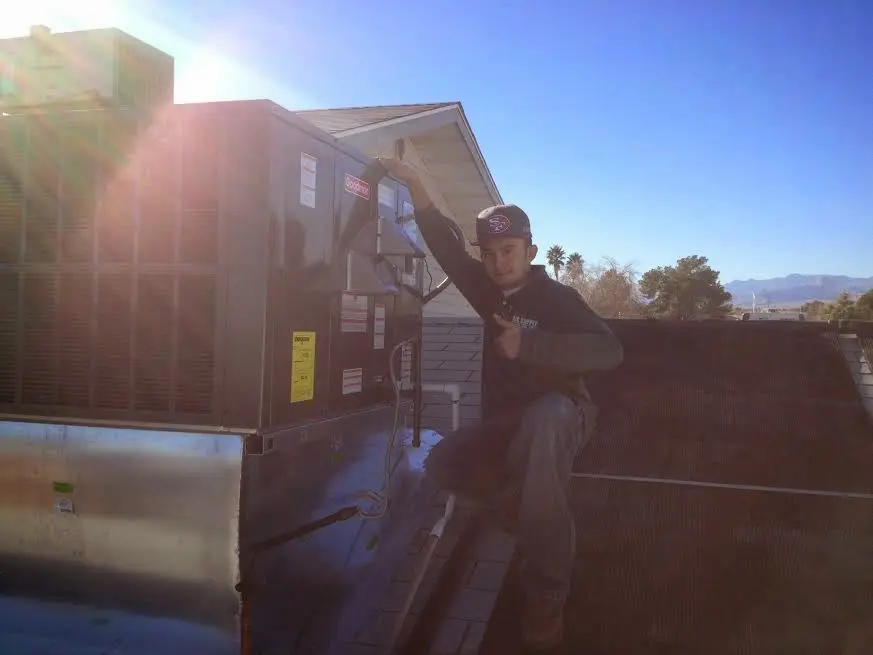 HVAC technician performing AC Tune-Up on a rooftop unit in Basehor